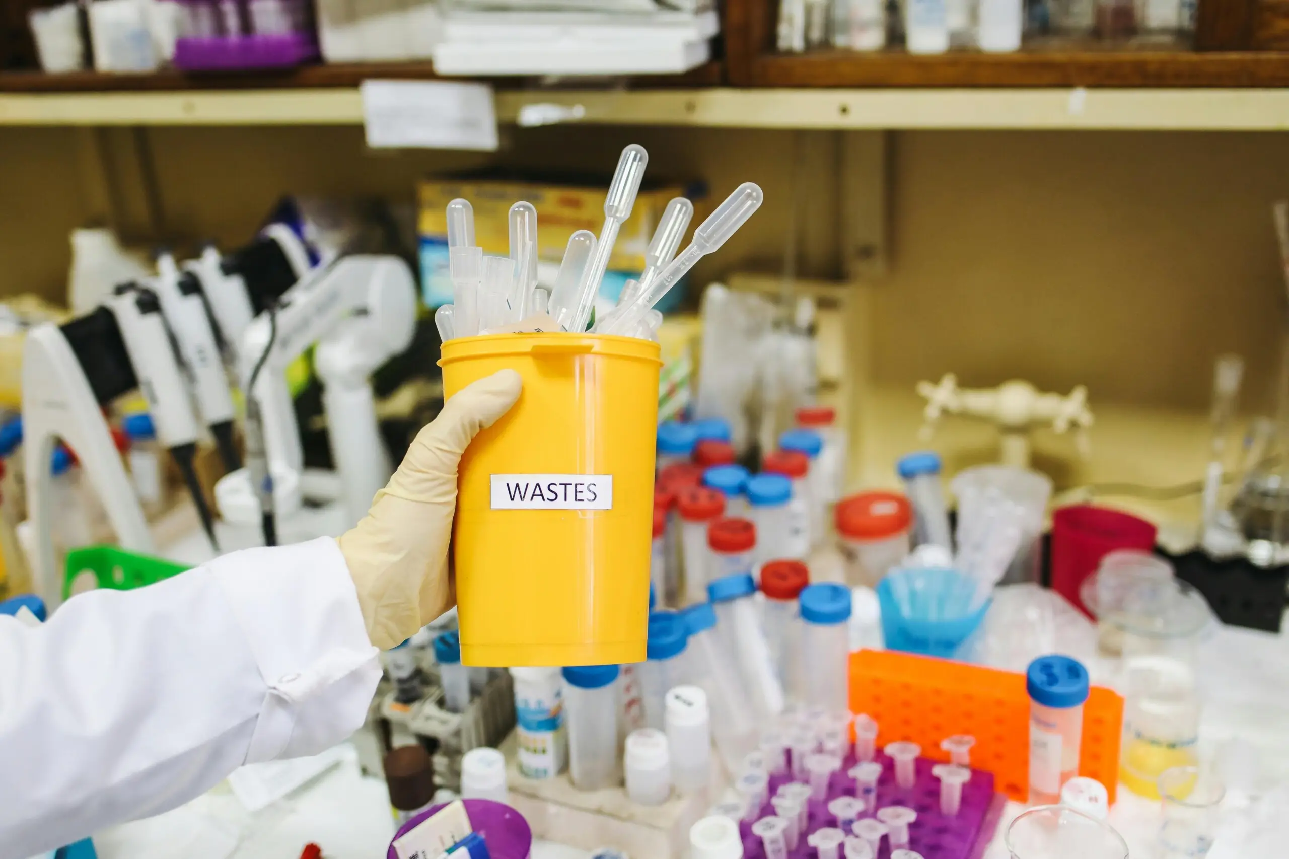 A box of medical sharps being put into a container for safe disposal of hazardous waste