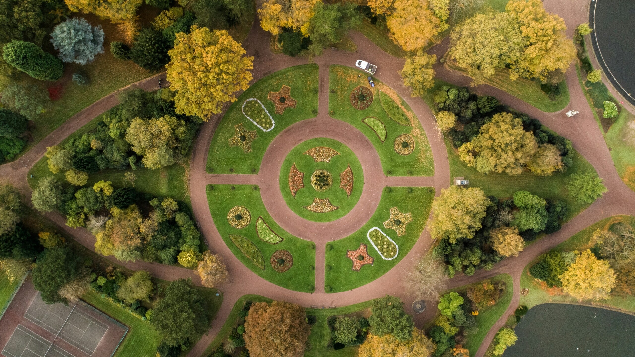 An aerial view of a park with lots of greenery and a large circular feature